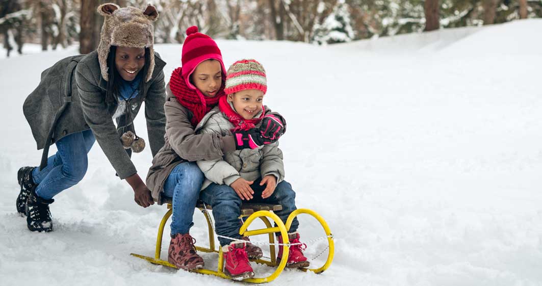 Mom with kids snow sledding